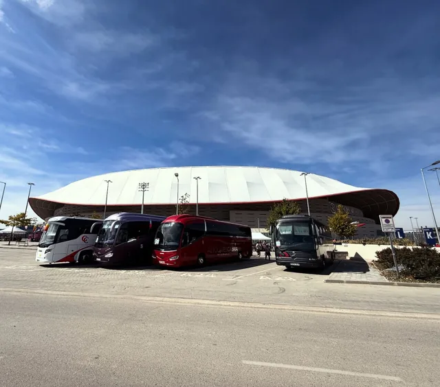 Vehículos de Autocares Cabria estacionados frente a un estadio